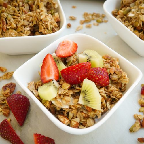 granola with bright fresh fruit topping - sliced strawberries and kiwis